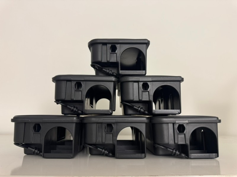 Une pile de bo&icirc;tes de d&eacute;ratisation en plastique noir est soigneusement dispos&eacute;e en forme de pyramide dans le canton du Valais, pr&ecirc;tes &agrave; &ecirc;tre utilis&eacute;es pour le contr&ocirc;le des rongeurs.