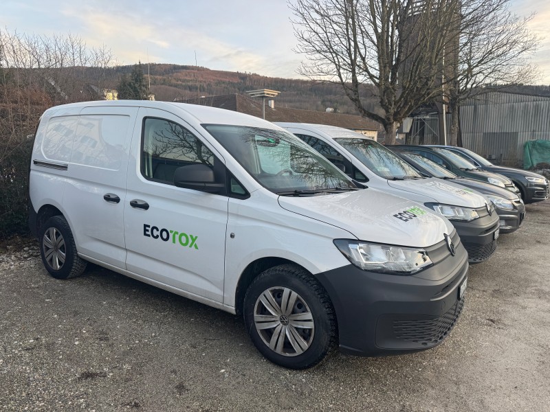 Une camionnette blanche Ecotox est gar&eacute;e avec d&rsquo;autres v&eacute;hicules similaires dans le canton du Valais, pr&ecirc;te pour les interventions de lutte antiparasitaire et de d&eacute;sinfection.